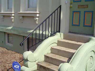 Decorative single stair rail mounted to concrete stairs